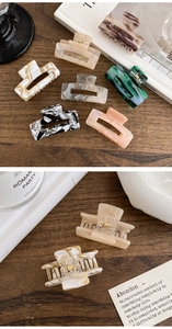 Close-up of elegant acetate hair claws in marble and tortoiseshell patterns with gold springs