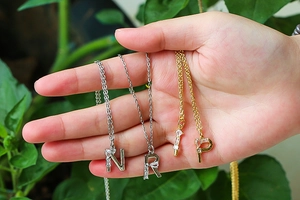 Three 18K gold and silver letter necklaces N R P with shimmering zircon pendants