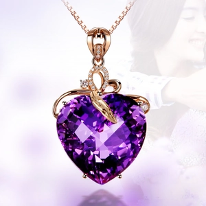 Detail of a 18K rose gold heart amethyst pendant with intricate ribbon and diamond accents