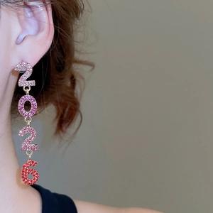 Détail de boucles d'oreilles 2026 pendantes serties de cristaux roses et rouges brillants