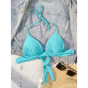 Sky blue halter bikini top with front knot and ruched cups on a beach setting
