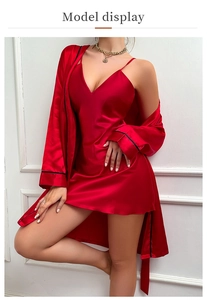 Detail of red satin pajamas set with deep V-neck camisole and lace-up robe with black piping