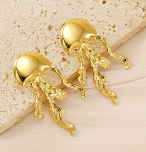 Polished gold jellyfish earrings with elegant tentacles on beige stone and satin