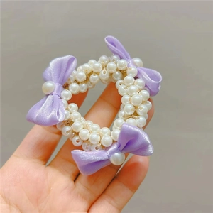 Elegant pearl hair tie featuring white faux pearls and delicate purple ribbon bows