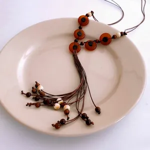 Ethnic bohemian beaded necklace with amber resin rings and wooden tassel accents