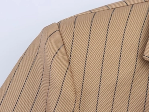 Close-up of brown pinstripe linen blend fabric showing twill weave and shoulder seam
