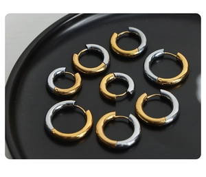 Detailed macro view of two-tone gold and silver stainless steel hoop earrings in various sizes