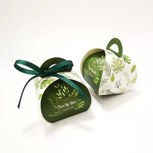 Detail of green tropical leaf pattern candy box with ribbon handle and gold text