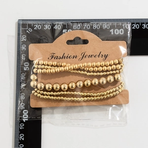 Golden heart beaded bracelets on display card with ruler measurement for size reference