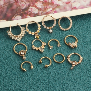 Close-up of golden seamless piercing rings with zircon, bee, and daisy designs