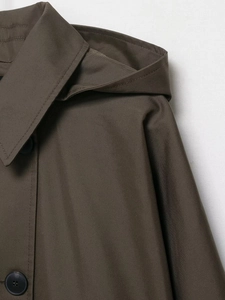Detail of dark olive brown waterproof trench coat showing twill fabric and large buttons