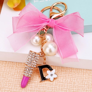 Close-up of sparkling rhinestone lipstick charm with pink organza bow and pearl details