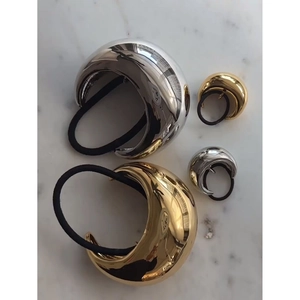 Gold and silver metallic hair ties in two sizes on a marble background with elastic bands