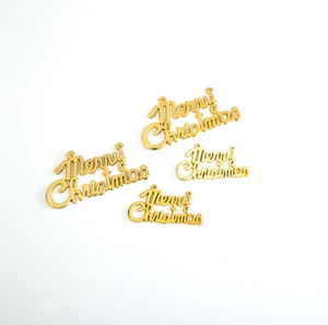 Close-up of four golden Merry Christmas hanging tags for festive cake decoration