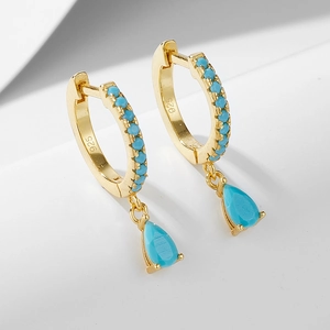 Detail of S925 sterling silver gold earrings with turquoise inlay and teardrop charm