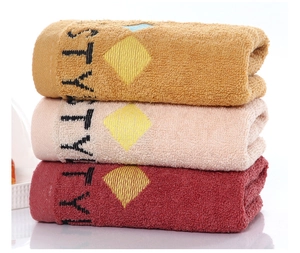 Close-up of soft thick cotton bath towels in yellow, pink and burgundy colors
