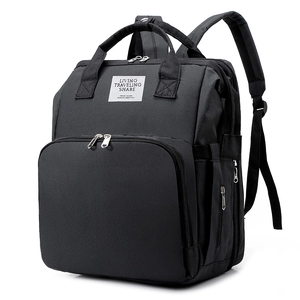 Detail view of the black multi-functional diaper bag featuring the front woven logo label