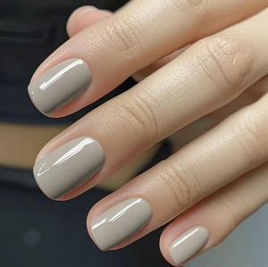 Close-up of short square taupe glossy press-on nails for a minimalist look