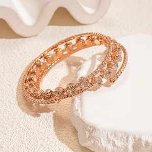 Detail of rose gold triple-layer cuff bracelet with sparkling zircon stones and open design