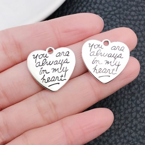 Makroaufnahme von silbernen Herzanhängern mit der Gravur 'you are always in my heart'