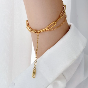 Close-up of double-layer golden paperclip chain bracelet with K18 stamp and extender