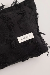 Close-up of black cotton linen cosmetic bag with frayed texture and H & R BAG label