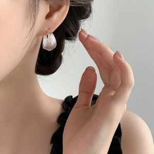Minimalist silver-plated multi-layer C-shaped hoop earrings worn by a model