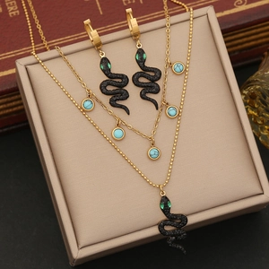 Detail of gold double-layer necklace with black snake pendant and turquoise accents