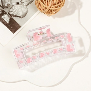 Detail of pink heart pattern on a transparent acrylic hair claw clip for women
