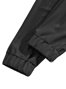 Detailed close-up of elasticized cuffs on black linen blend trousers with waffle texture