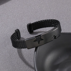 Detail of black stainless steel woven bracelet with hollow star and brushed metal finish