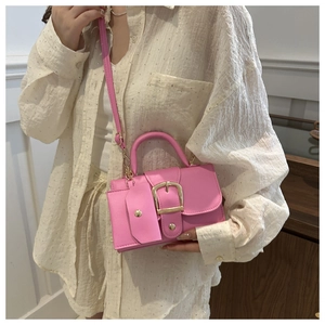 Fashionable pink crossbody bag with gold buckle and matching mini pouch on model