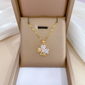 Luxurious gold clover jewelry set with heart-shaped crystals in a premium gift box