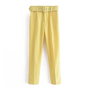 Detalle de los pantalones de cintura alta en amarillo claro con cinturón y textura de tela