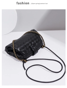 Detailed view of the black woven leather shoulder bag with chic chain strap and flap.