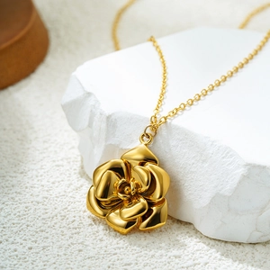 Elegant 18K gold-plated stainless steel camellia flower necklace on white marble base