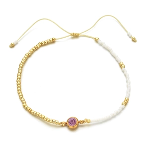 Detailed close-up of a beaded bracelet with purple zircon and beige adjustable cord