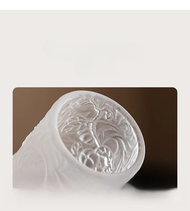 Close-up of frosted glass cup rim with smooth edge and embossed peach texture details