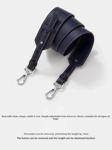 Close-up of dark blue lychee grain leather bag strap with silver metal hooks