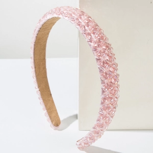 Elegant pink crystal beaded headband with floral patterns on white geometric display stand