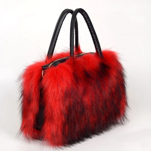 Detailed view of bicolor faux fur tote bag with black leather handles and golden zipper