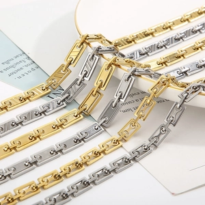 Detailed close-up of gold and silver stainless steel rectangular link chains on a tray