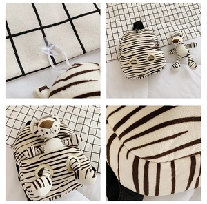 Detail view of tiger stripe plush backpack with metal eyelets and sucker attachment