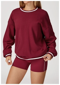 Detail of burgundy sweatshirt with striped ribbing and matching high waist biker shorts