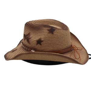 Detail of western straw cowboy hat with brown gradient, leather band and star studs