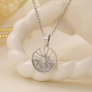 Silver geometric hollow pendant necklace with radiant lines and crystals on a white stand