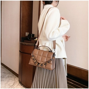 Brown quilted crossbody bag featuring a chic tortoiseshell chain and leather handle