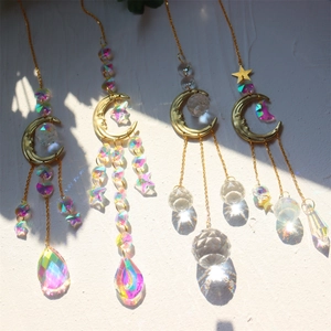 Detail shot of golden sun moon crystal suncatchers casting rainbow light on a wall