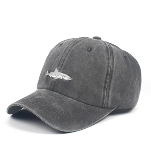 Detailed embroidery of a white shark on dark grey washed vintage style baseball cap