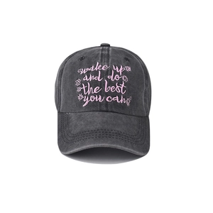 Detail of pink embroidered quote on washed black cotton canvas baseball cap